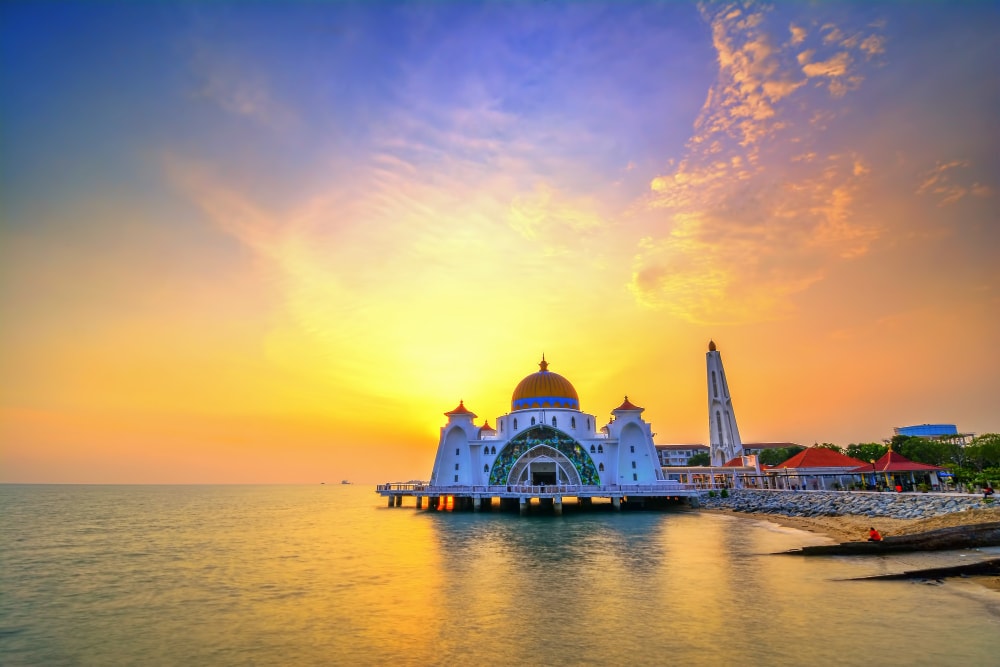 Mezquita Flotante Masjid Selat de Malaca durante un atardecer vibrante.