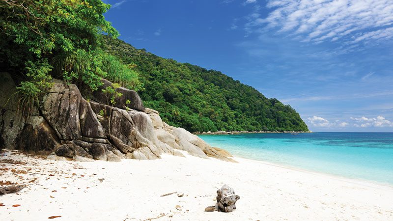 Playa de las Islas Perhentians con arena blanca, agua cristalina y vegetación tropical.