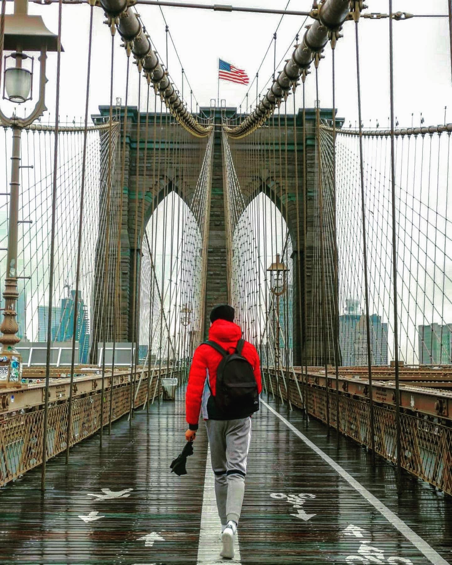 Persona en el puente de Brooklyn con vistas a Manhattan.