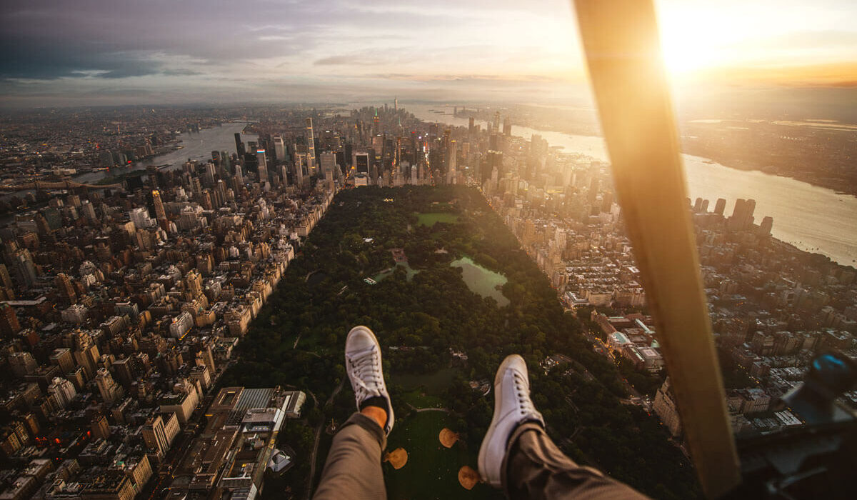 Vista aérea de Manhattan desde un helicóptero con los pies colgando.