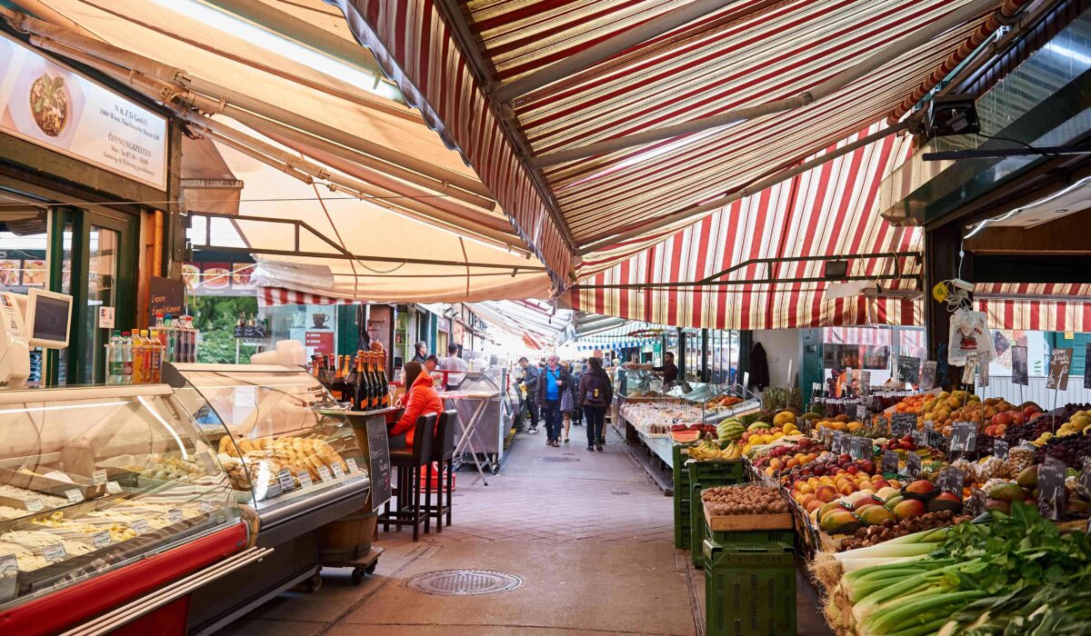 Colorido mercado Naschmarkt en Viena, con una variedad de puestos de comida y productos frescos.