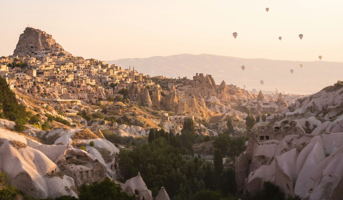 Pueblo de Capadocia con globos aerostáticos sobre las chimeneas de hadas