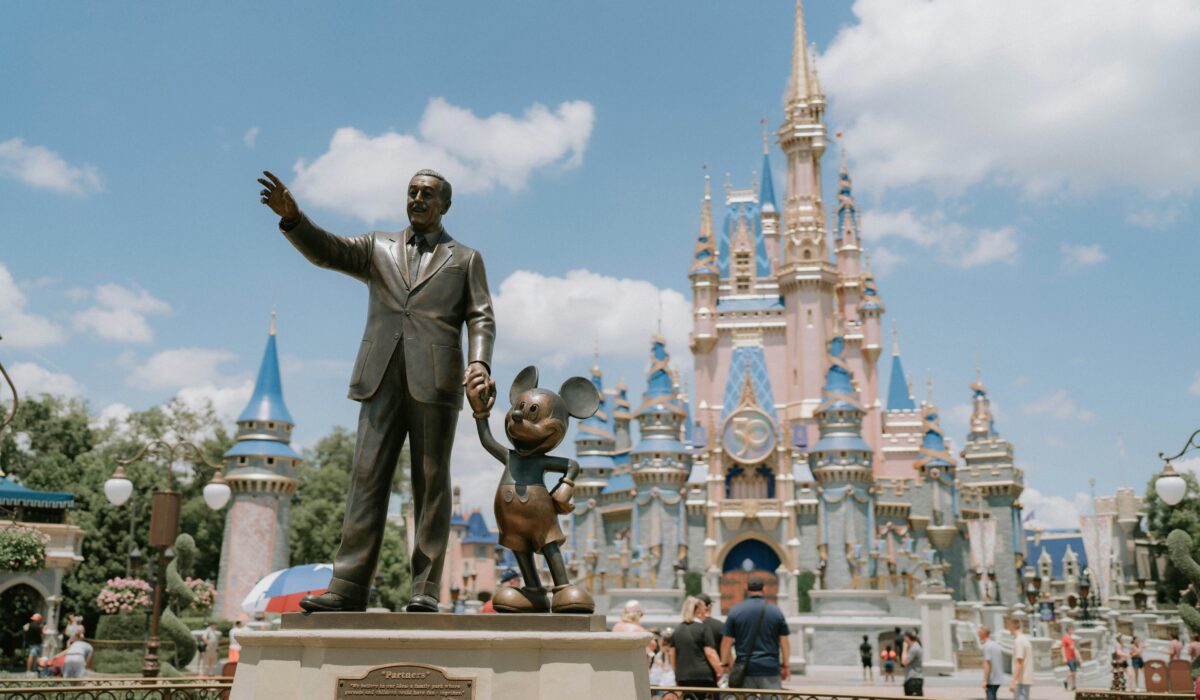 Castillo de Magic Kingdom iluminado durante el día, destacando su arquitectura mágica y rodeado de un hermoso paisaje