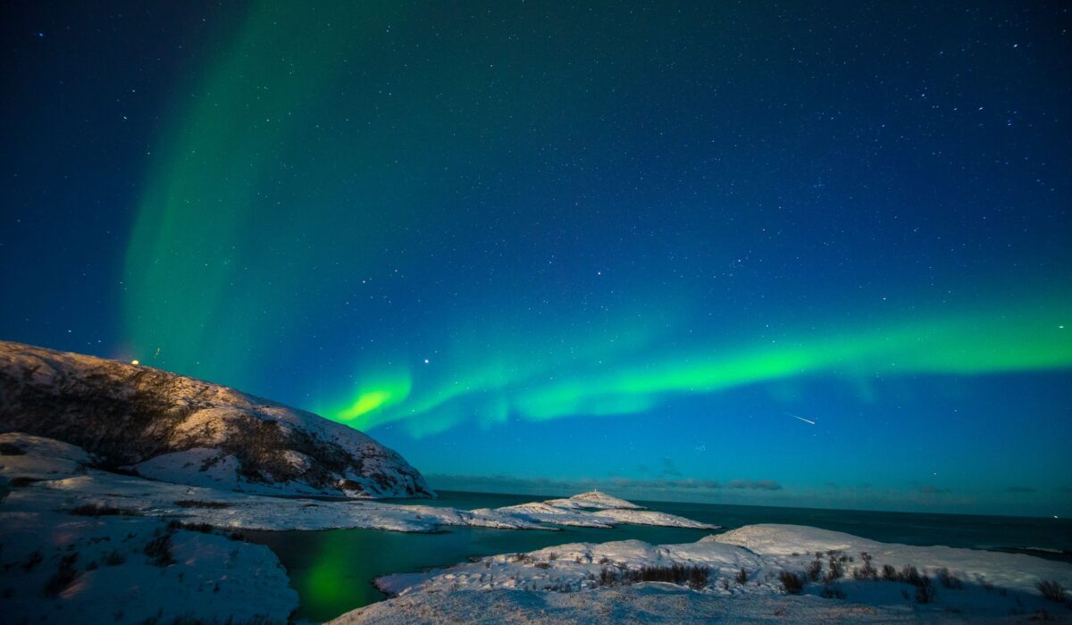 Auroras boreales iluminando el cielo sobre un paisaje nevado