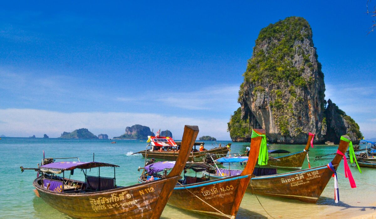 Playa de Krabi en Tailandia con barcos tradicionales, mar cristalino y arena blanca