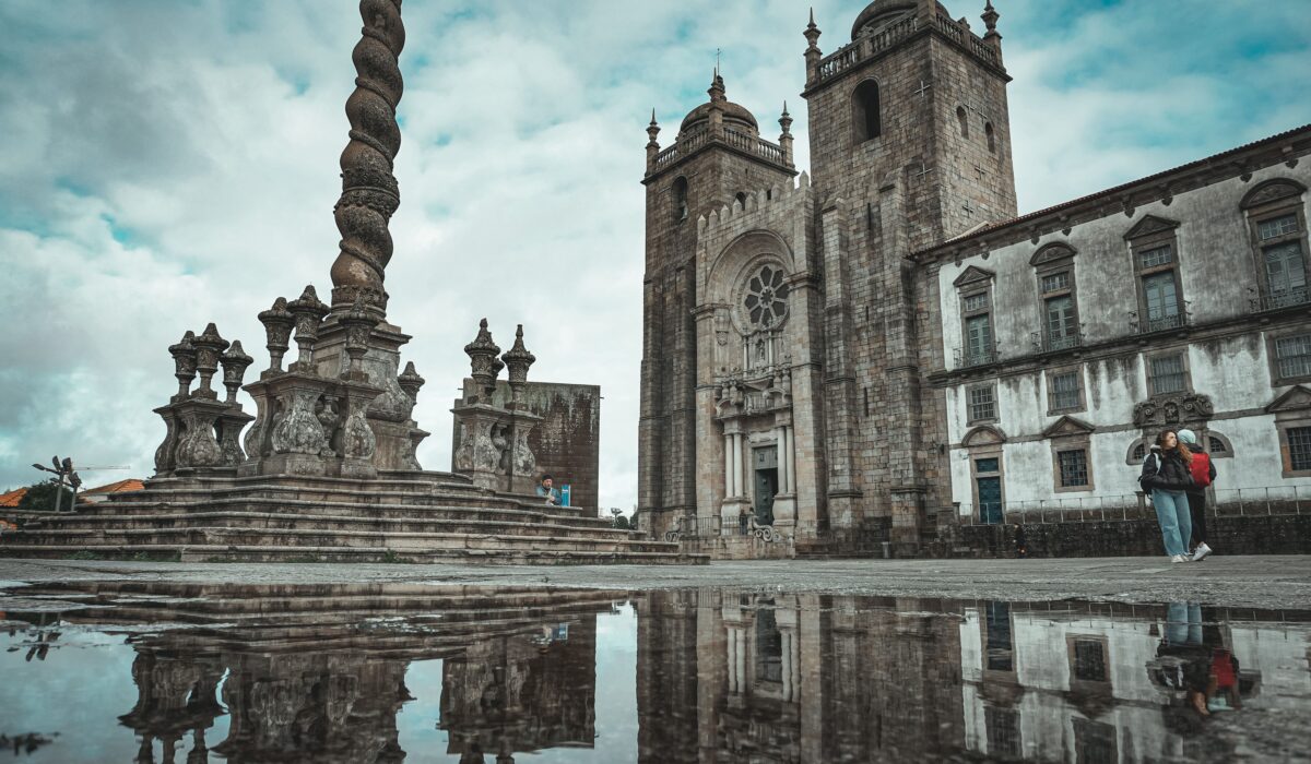 Catedral de Oporto en un día lluvioso con reflejo en un charco