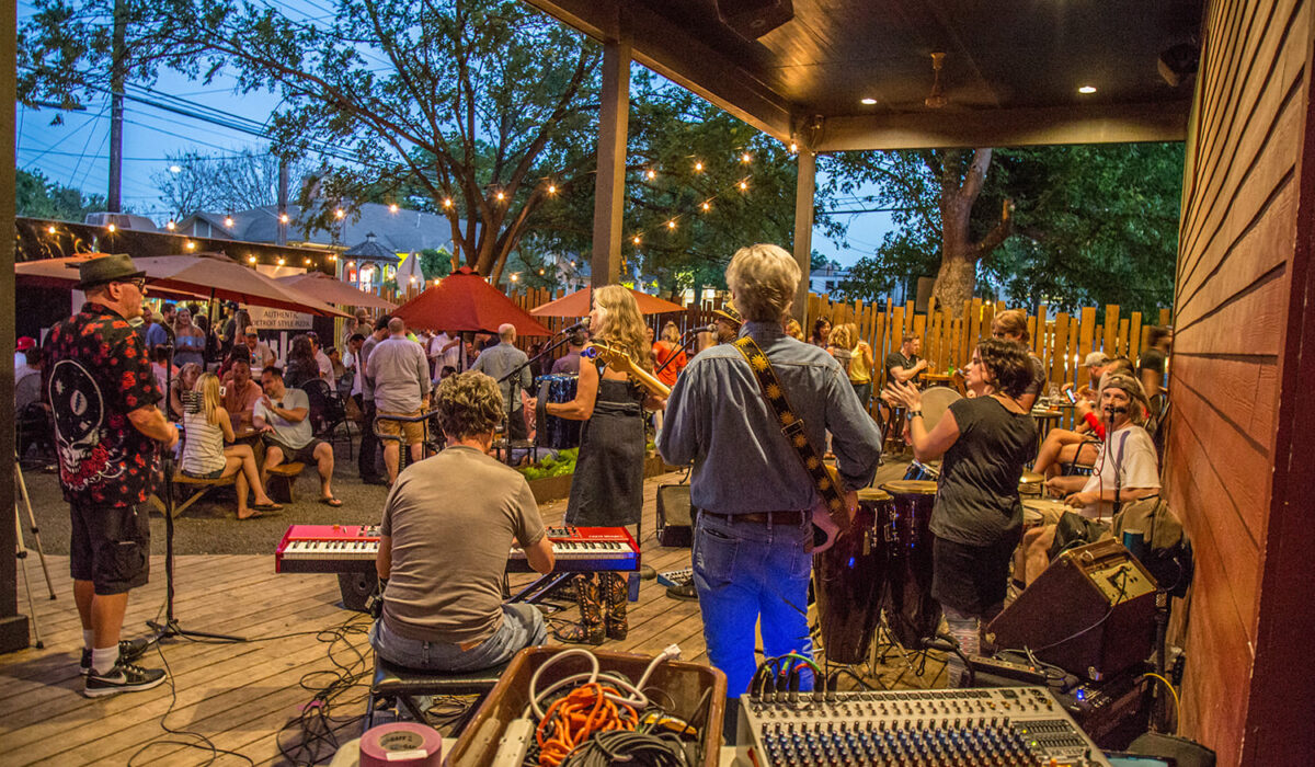 Gente disfrutando de música en vivo en Rainy Street, Austin, Texas.