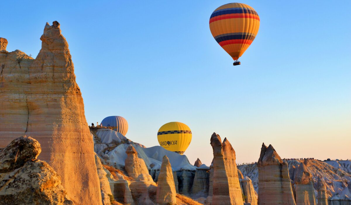 Chimeneas de hadas de Capadocia con globos aerostáticos en el cielo al amanecer.