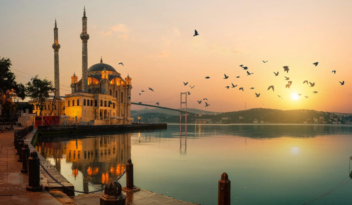 Vista de la Mezquita de Ortaköy iluminada por el atardecer, con el Bósforo al fondo.