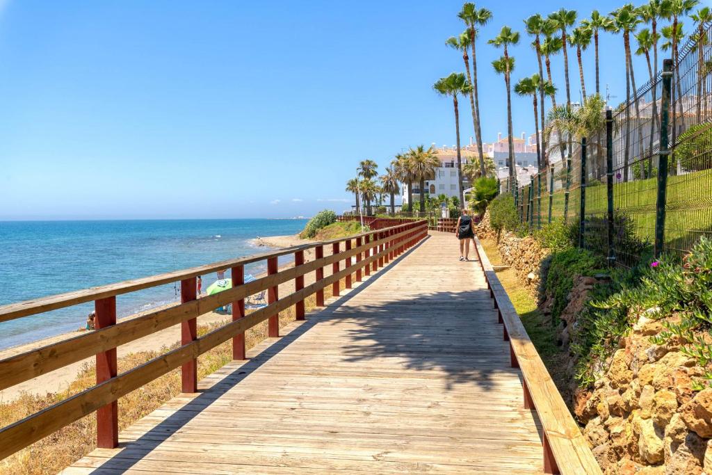 Pasarela sobre la playa de Cabopino, Marbella, rodeada de arena y mar.