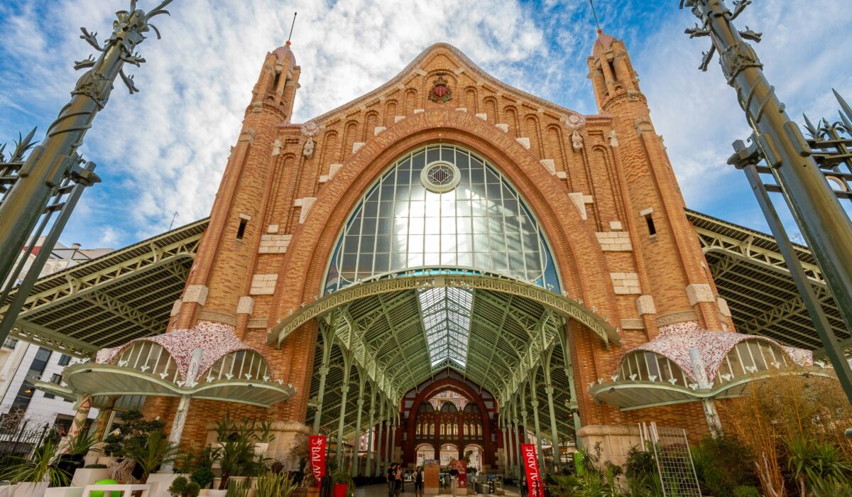 Mercado de Colón en Valencia, edificio modernista con cafeterías y restaurantes, un lugar ideal para disfrutar de la gastronomía local y la arquitectura.