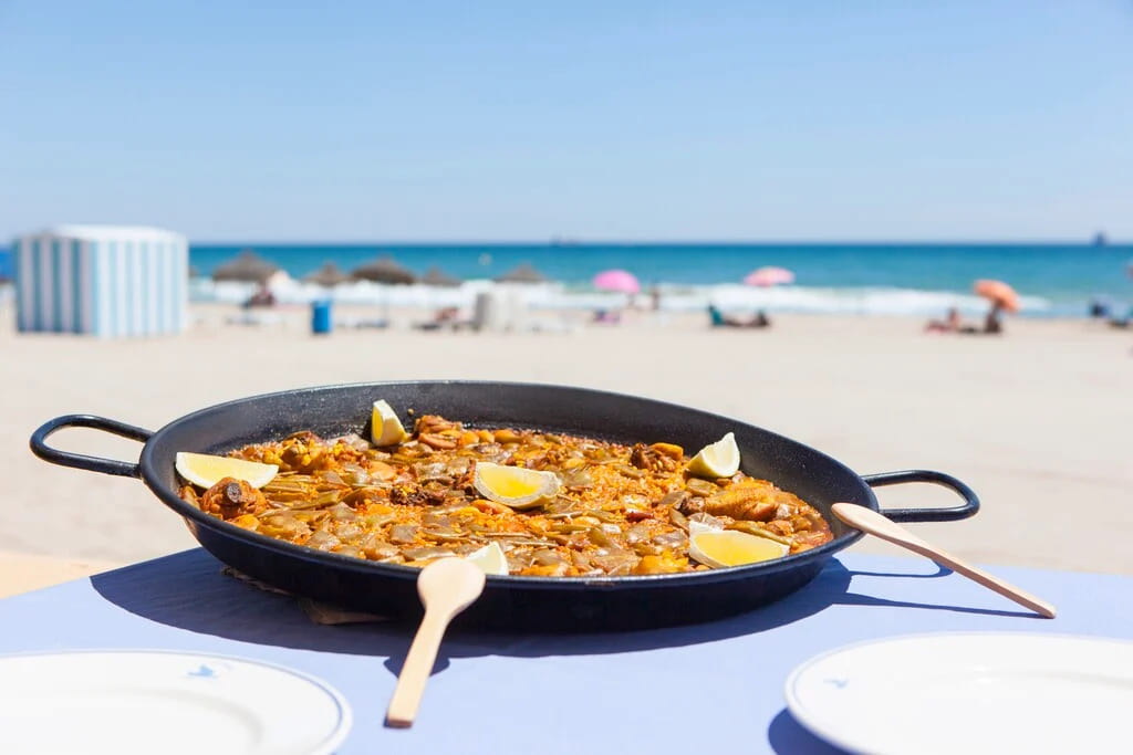 Paella valenciana tradicional servida en una terraza en Valencia, una de las mejores experiencias gastronómicas de la ciudad.