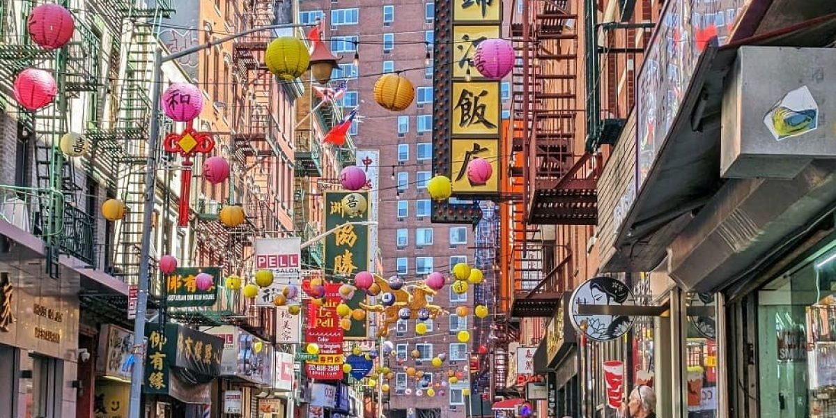 Calle de Chinatown en Nueva York, adornada con globos chinos y tiendas tradicionales.